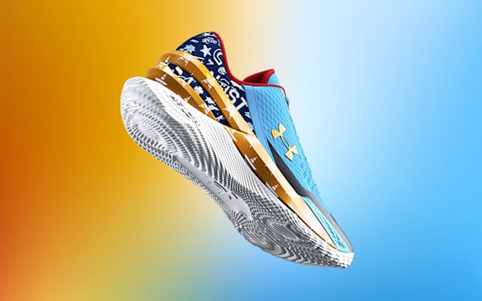 View of blue, gold, and white Under Armour shoe.